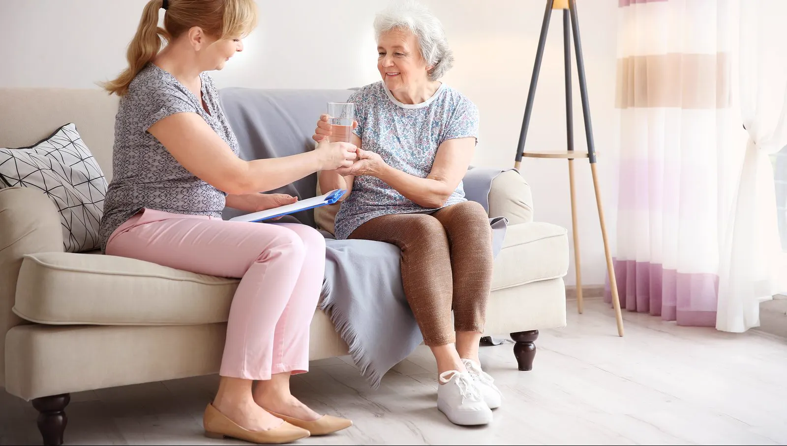 Professional caregiver and senior sharing a warm moment at home